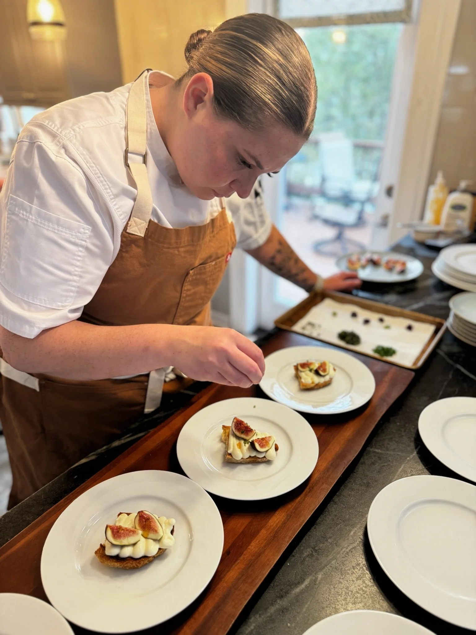 Chef Lizzie plating individual desserts for a private dinner.