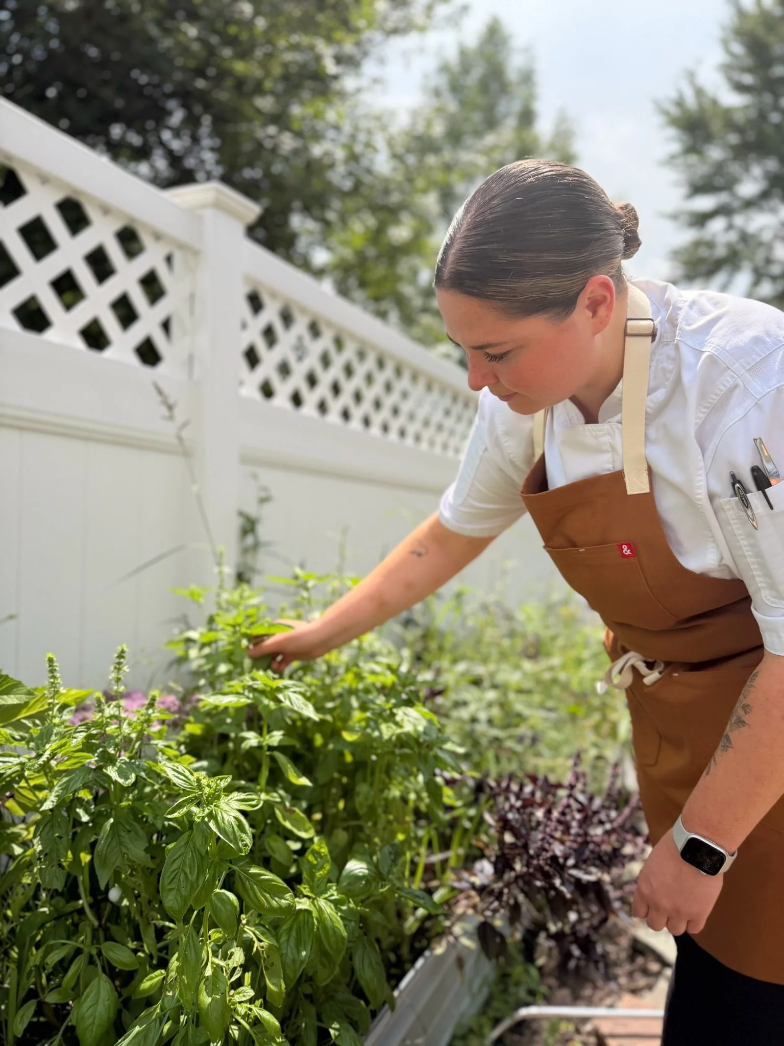 Chef Lizzie gathering herbs in her garden