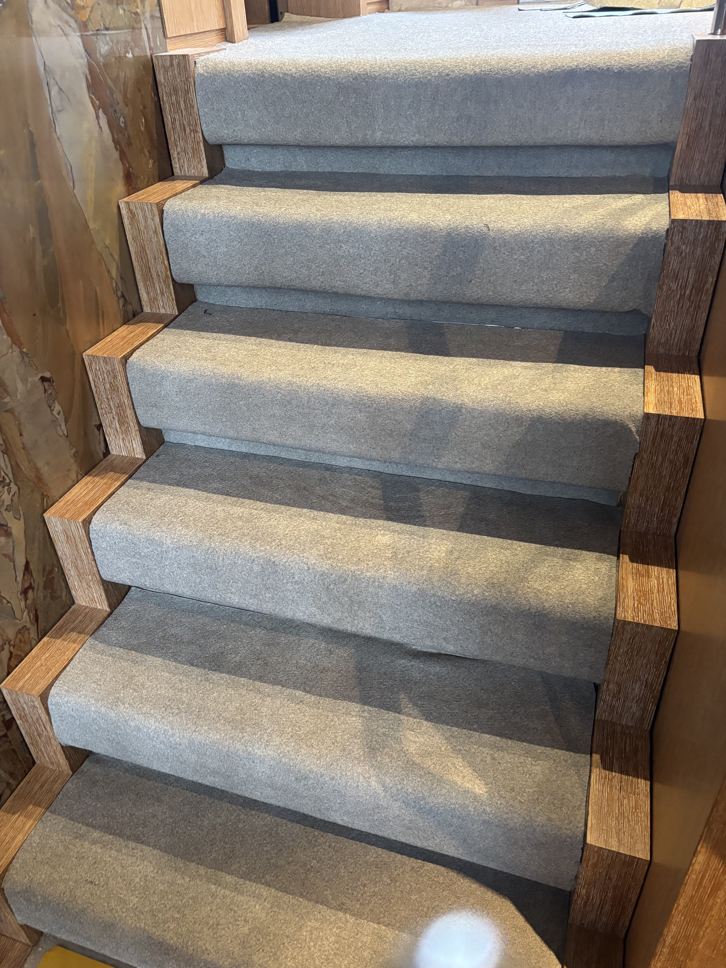 Escalier en bois avec moquette grise dans un navire