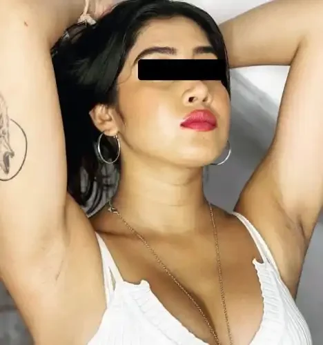 Close-up of a woman with dark hair, wearing hoop earrings and a white top, posing with her arms raised and her eyes blacked out.