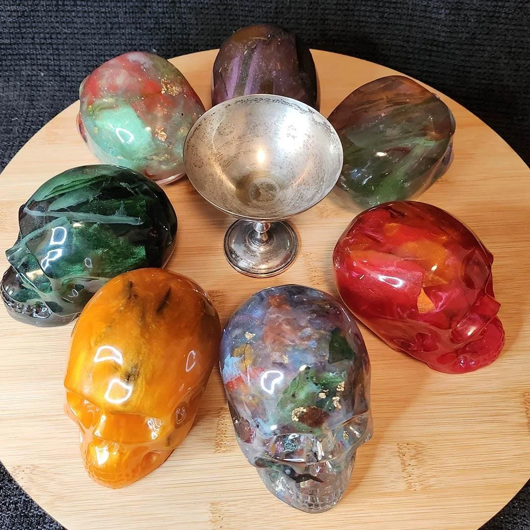 Several Examples of Anti-Waste JoaraCrafts decorative skulls. In this picture you can see skulls around a silver goblet for scale. All skulls are approx 6 centimeters wide by 10 centimeters height. The goblet is slightly taller, but not as wide. The 