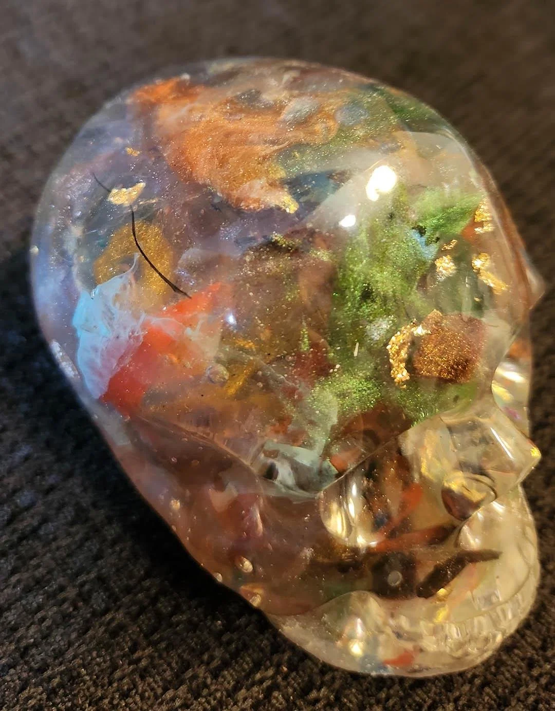 Detailed photo of a see through JoaraCrafts Anti-Waste Decorative Skull with multicolored bits and resin scraps inside