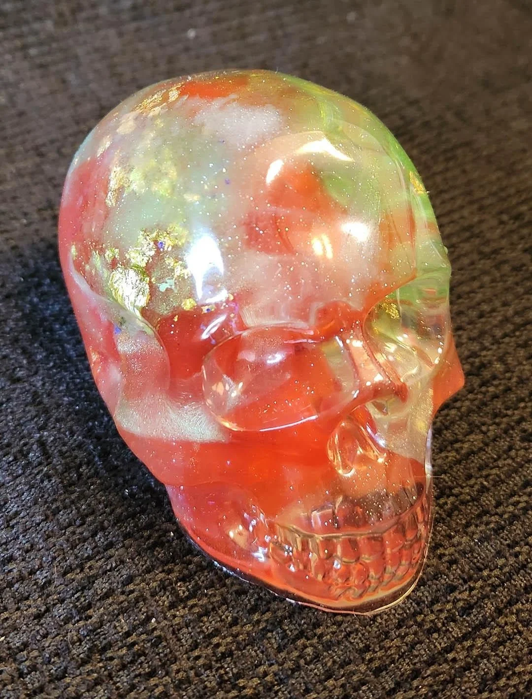 Detailed photo of a seethrough JoaraCrafts Anti-Waste Decorative Skull with red and green resin scraps inside