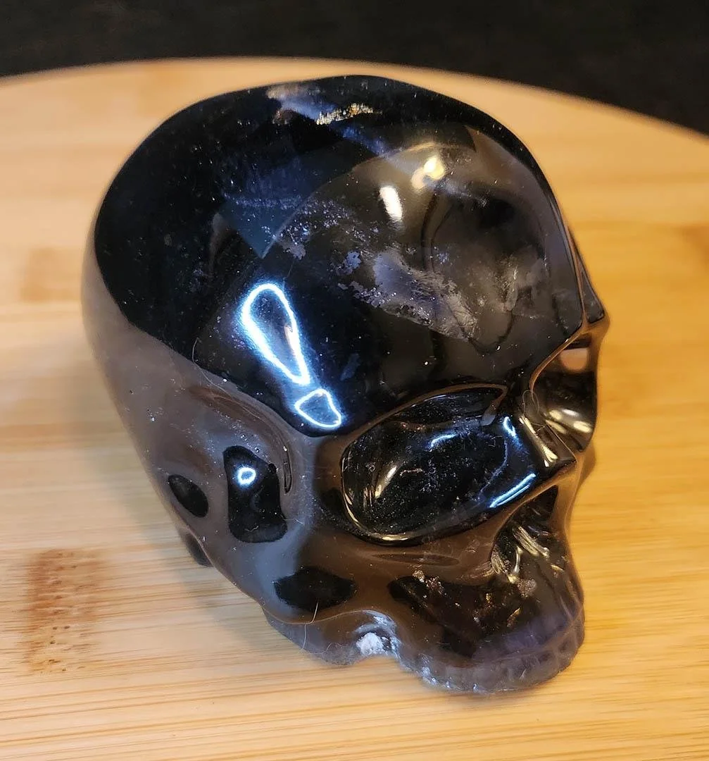 Detailed photo of a deep black JoaraCrafts Anti-Waste Decorative Skull with some black and dark blue scraps inside