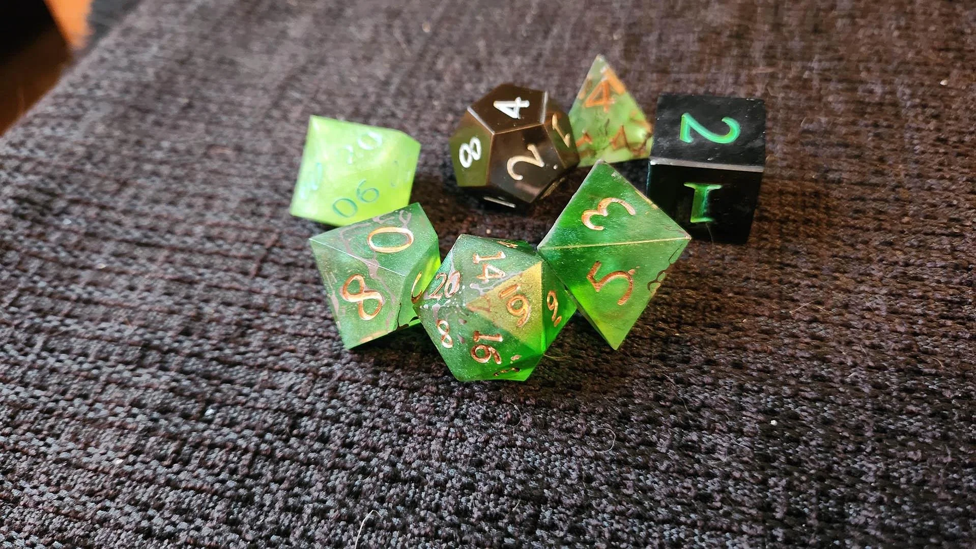 An example of how a JoaraCrafts mystery dice pack might look like. This specific set has a thematic green variant where all dice have different shades of green and a couple of them are darker dice with green numbers