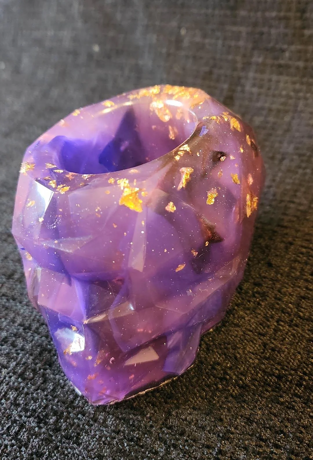 A detailed photo of one of the JoaraCrafts Anti-Waste Resin Geometric Skull Pen Holder. This skull is purple with gold flakes on the back. The photo is taken with a black background.