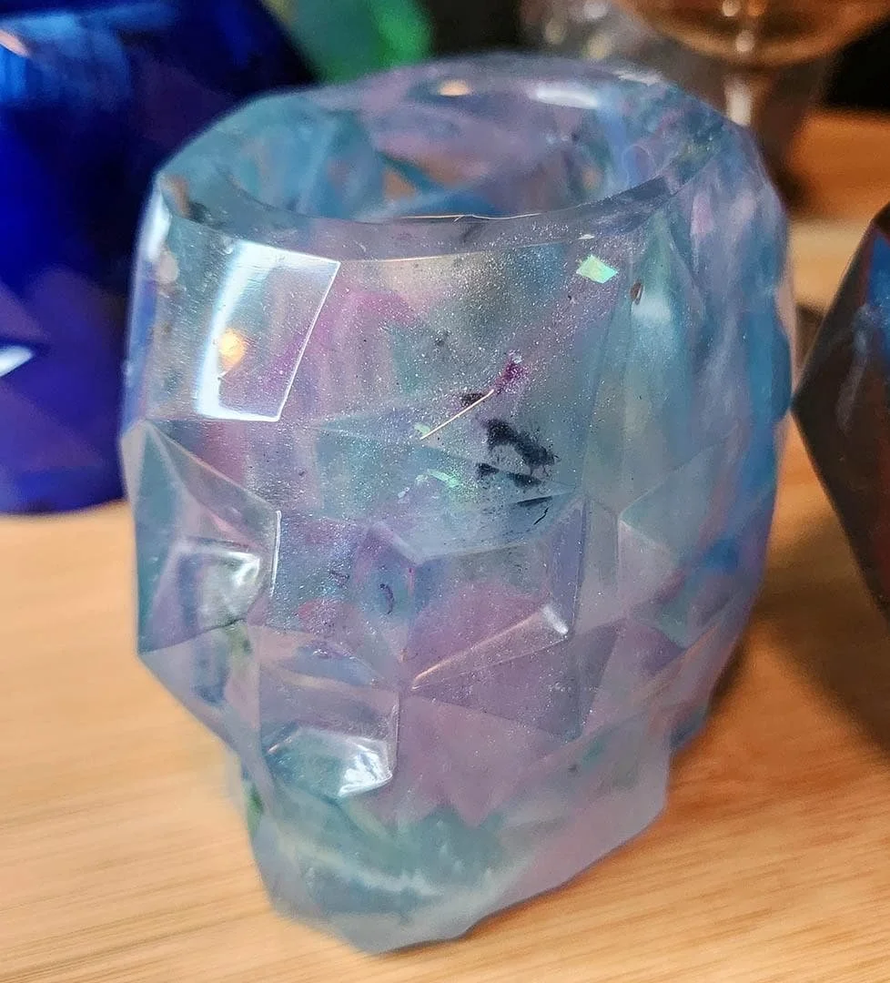 A detailed photo of one of the JoaraCrafts Anti-Waste Resin Geometric Skull Pen Holder. This skull is purple and light blue. The photo is taken with wooden background