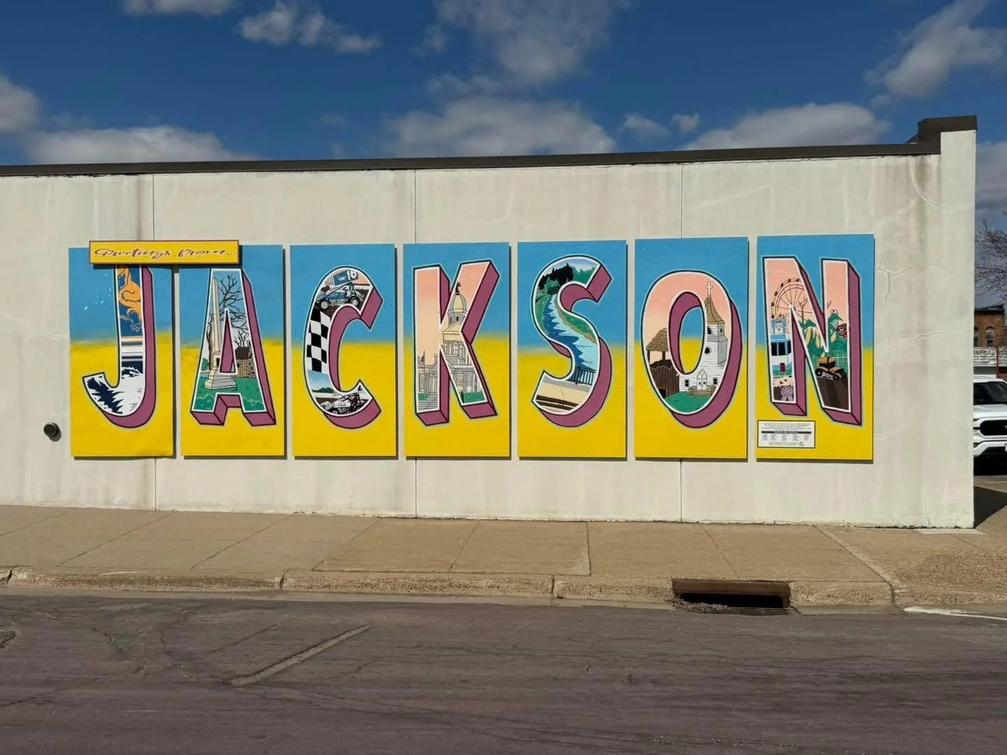 Colorful mural spelling 'Jackson' with illustrations representing local landmarks and scenery.