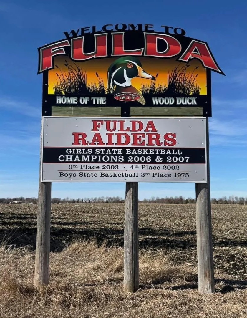 Sign welcoming visitors to Fulda, featuring a duck's head and mentions local sports championships and achievements.