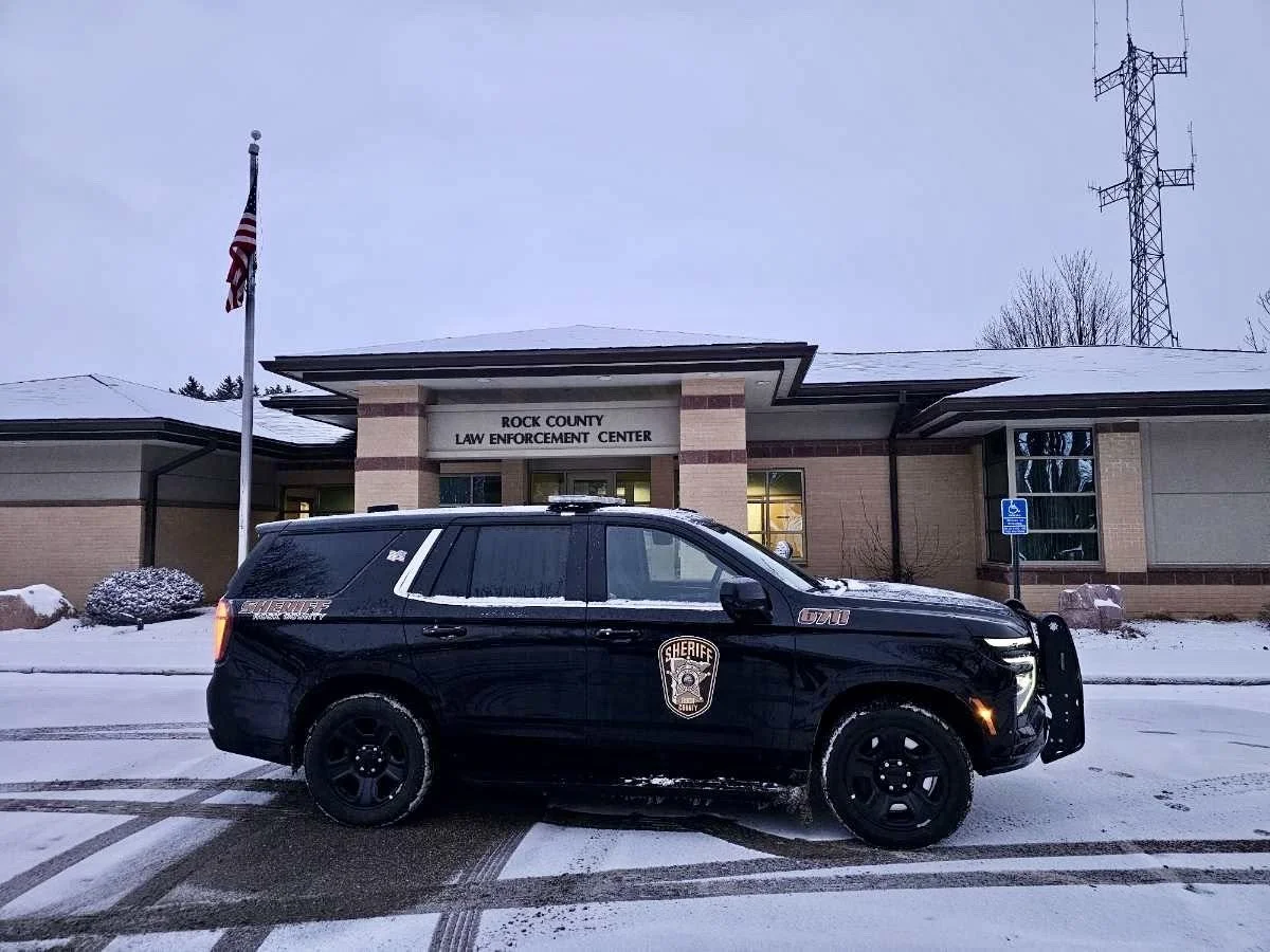 Sheriff's vehicle parked in front of Rock County Law Enforcement Center building on a snowy day.