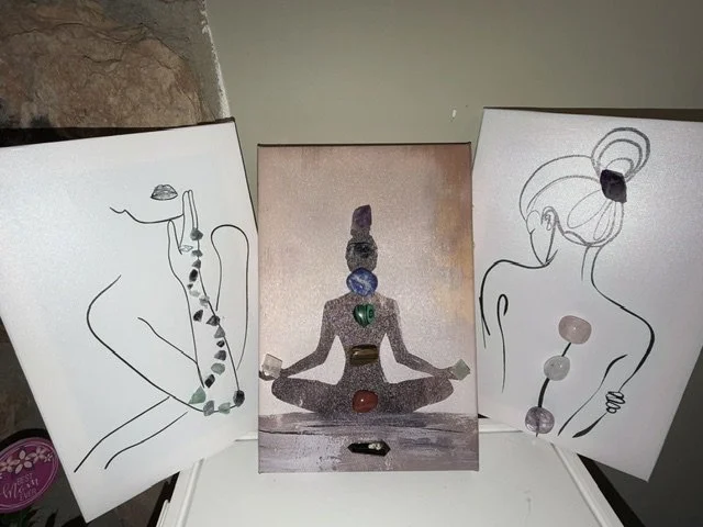 Three art prints with women in yoga poses, each with stones or jewelry placed on their bodies, and a center photo of a person meditating with stacked stones aligned vertically on their head and chest.
