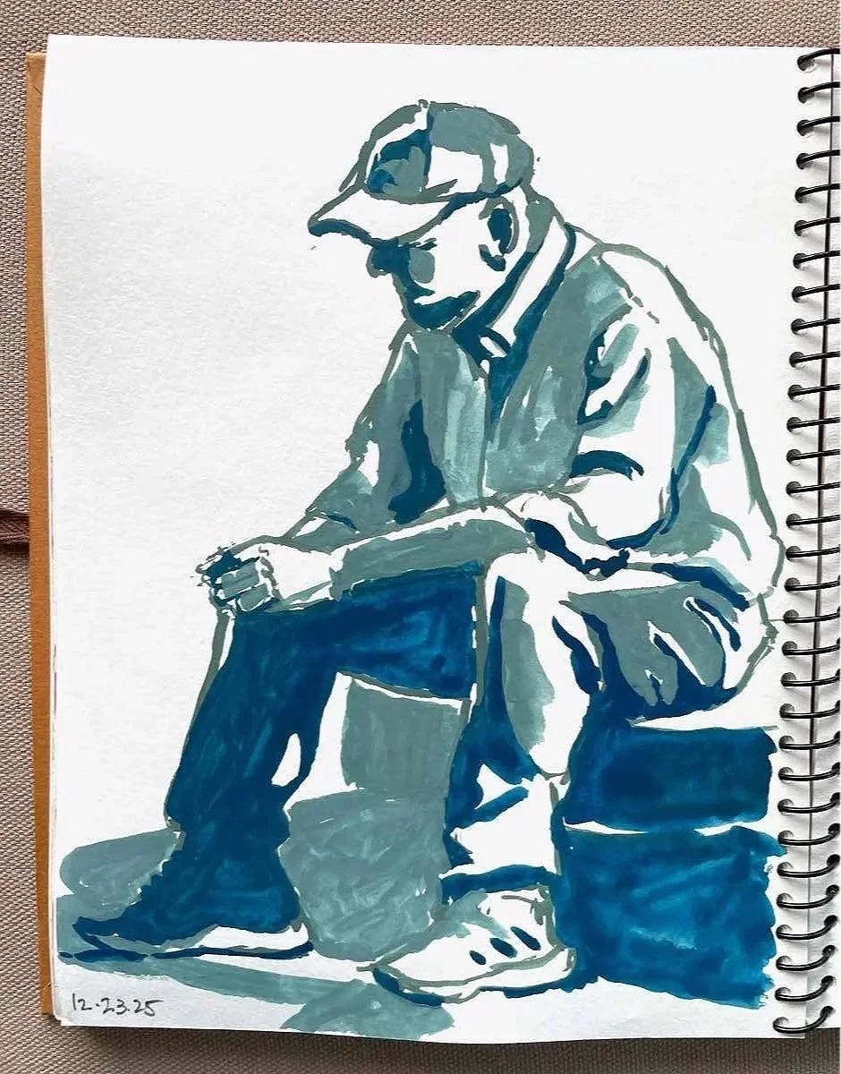 Watercolor sketch of a man sitting on a small suitcase, wearing sunglasses, a cap, a jacket, and sneakers, looking down at a phone, with a bag on the floor next to him. The date 12-23-25 is written in the bottom left corner.