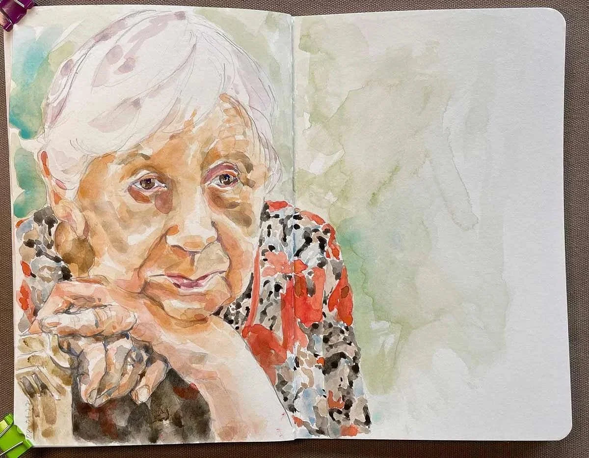 A watercolor portrait of an elderly woman with gray hair, wearing a colorful, patterned top with black, white, red, and gray colors, resting her chin on her hand with her fingers near her face.
