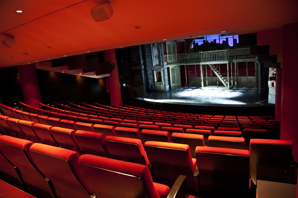 Backstage-Tour im English Theatre Frankfurt mit Blick auf die Theaterbühne, das Bühnenbild und den Zuschauerraum mit roten Samtsitzen.