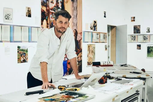 Tony Rizzi führt durch seine Ausstellung im Fotografie Forum Frankfurt, umgeben von Fotografien, Werkzeugen und Arbeitsmaterialien.