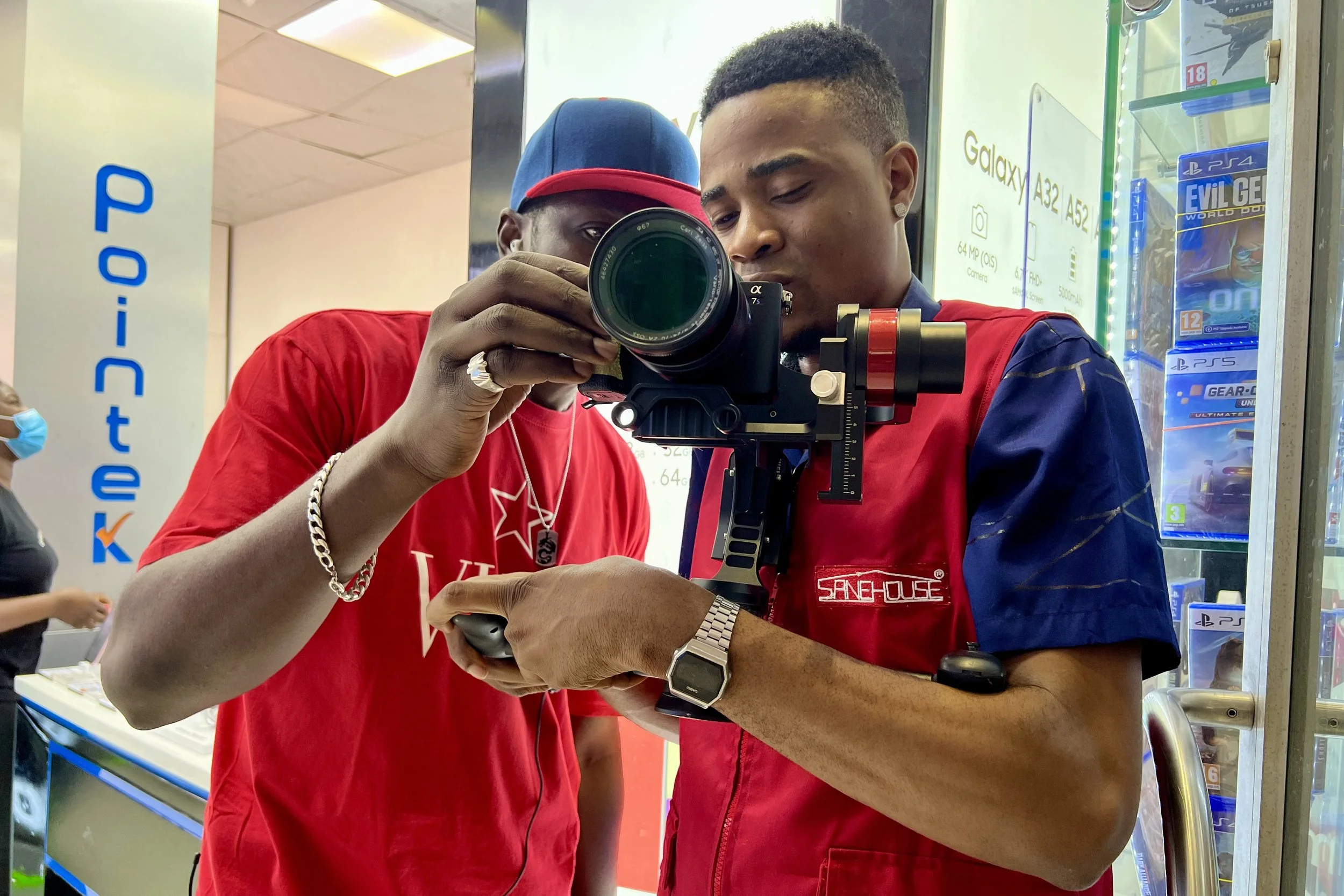 Sane House Media director  and a camera operator viewing footage on a professional camera mounted on a stabilizer. 