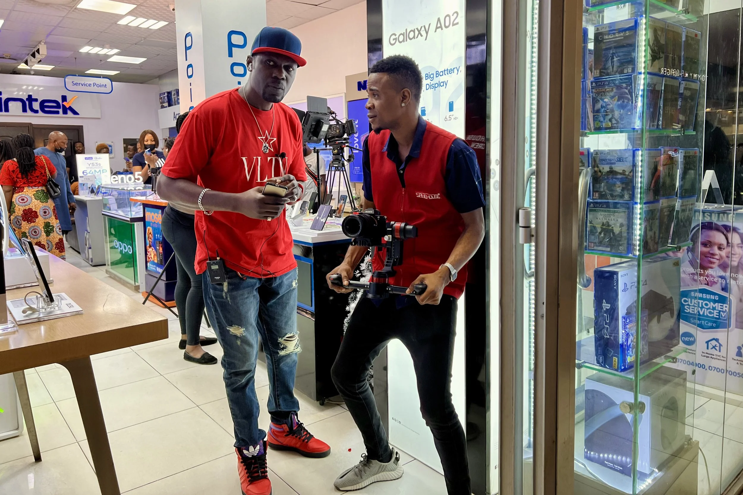 Sane House Media director and a camera operator during a video shoot,.The cameraman is holding a professional camera mounted on a stabilizer.