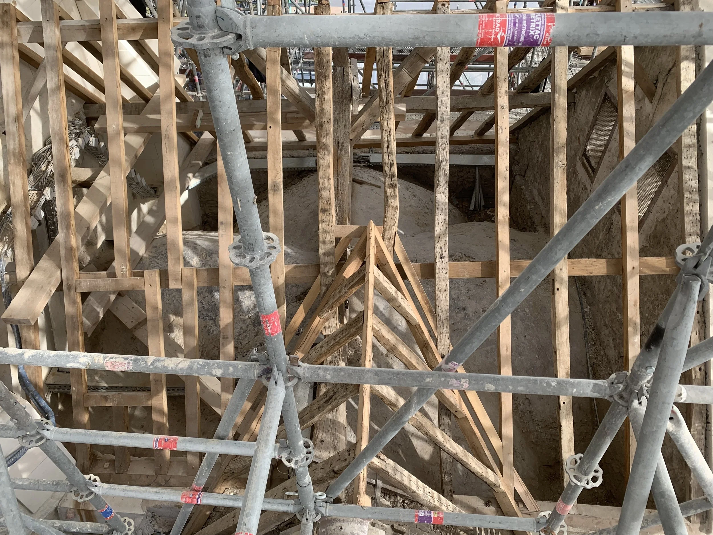 Scaffolding en construction avec des poutres en bois et des tuyaux en métal, vue du dessus.