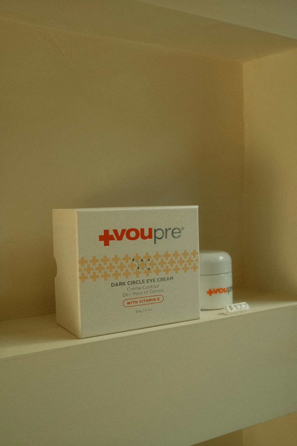 A box of You Pre Dark Circle Eye Cream with Vitamin E on a shelf beside a small white container.