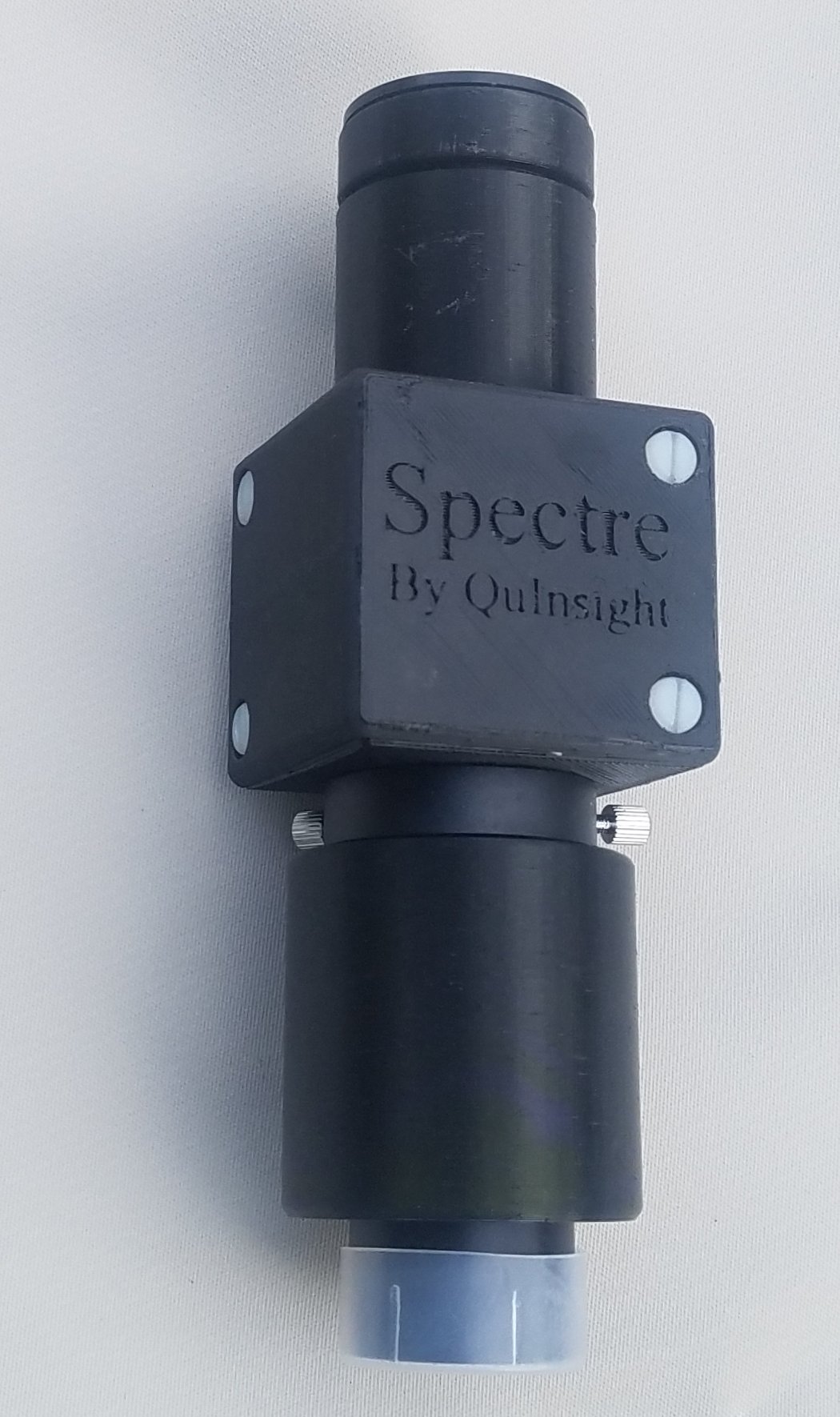 Close-up of a black metallic telescope with the label 'Spectre By Quinsight' on a square part of the instrument.