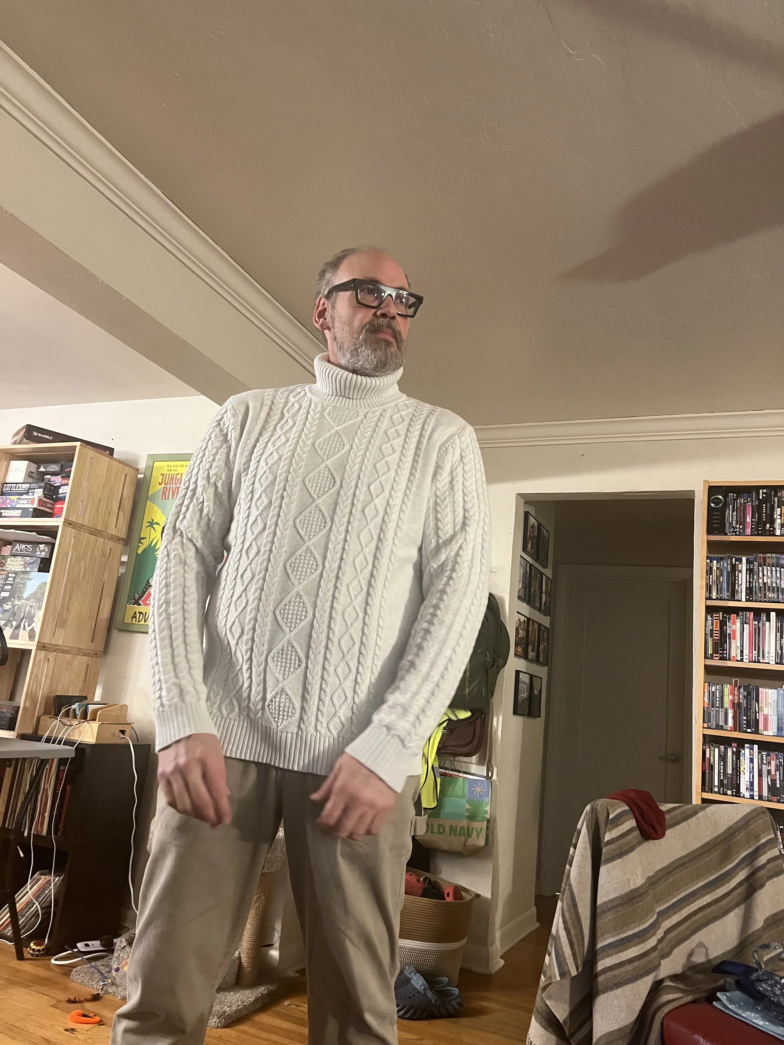 Wayne Rawley stands in his living room looking dashing and smart.