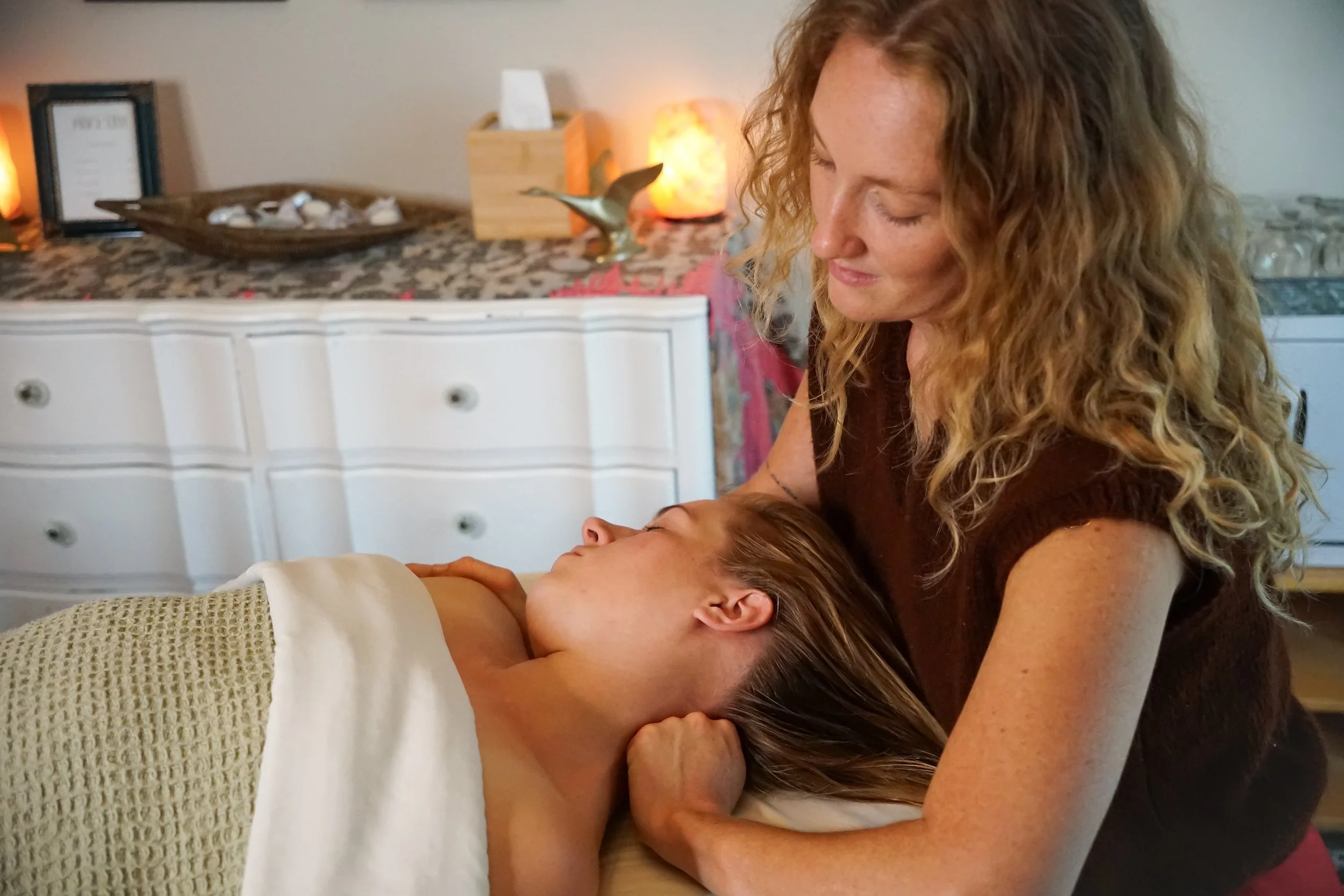 A woman with curly hair giving neck massage