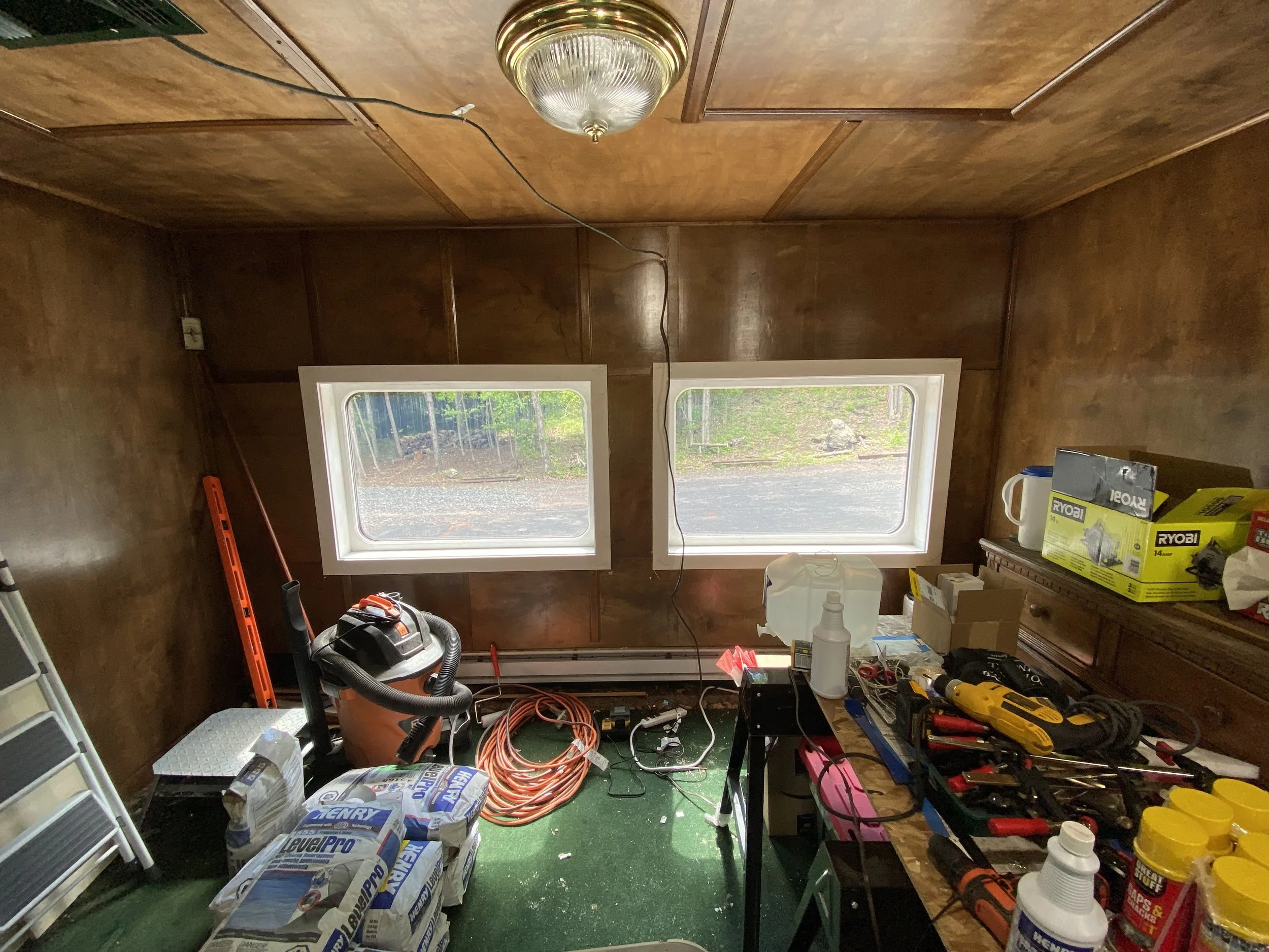 A train interior cluttered with tools and construction equipment during a renovation. 