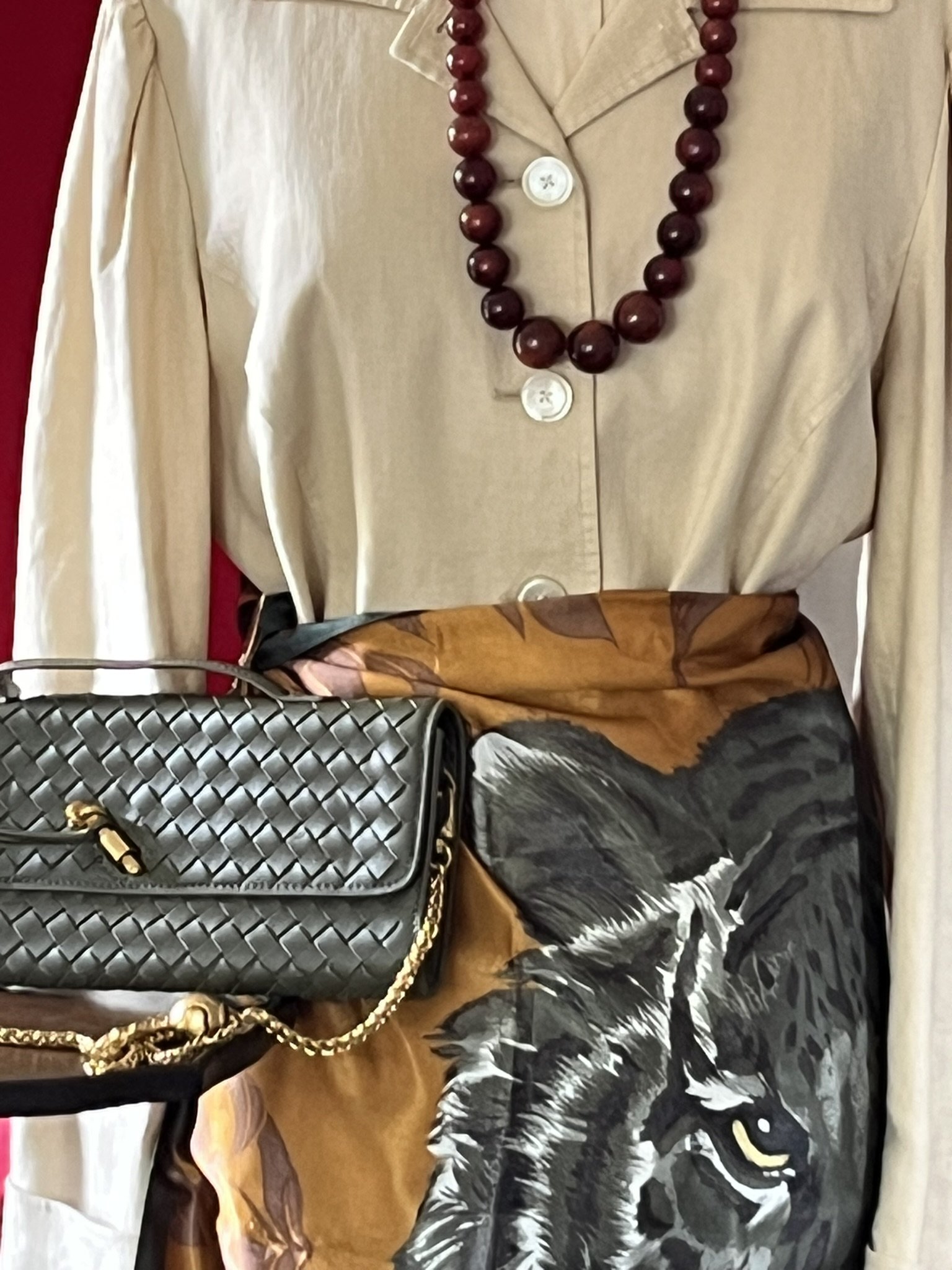Mannequinn dressed in Tiger Scarf Skirt, wearing large beaded Bakelite necklace next to luxury green faux leather clutch with heavy gold strap