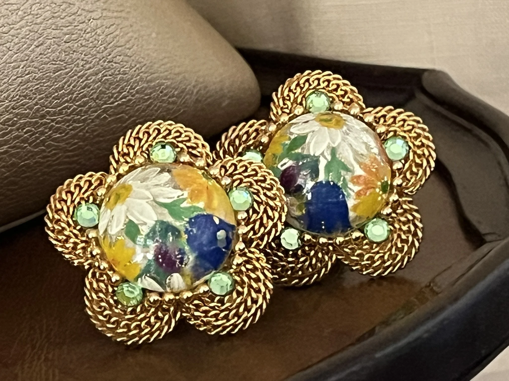 Close-up of decorative glass ornaments with floral and multicolored patterns, set on a dark surface.