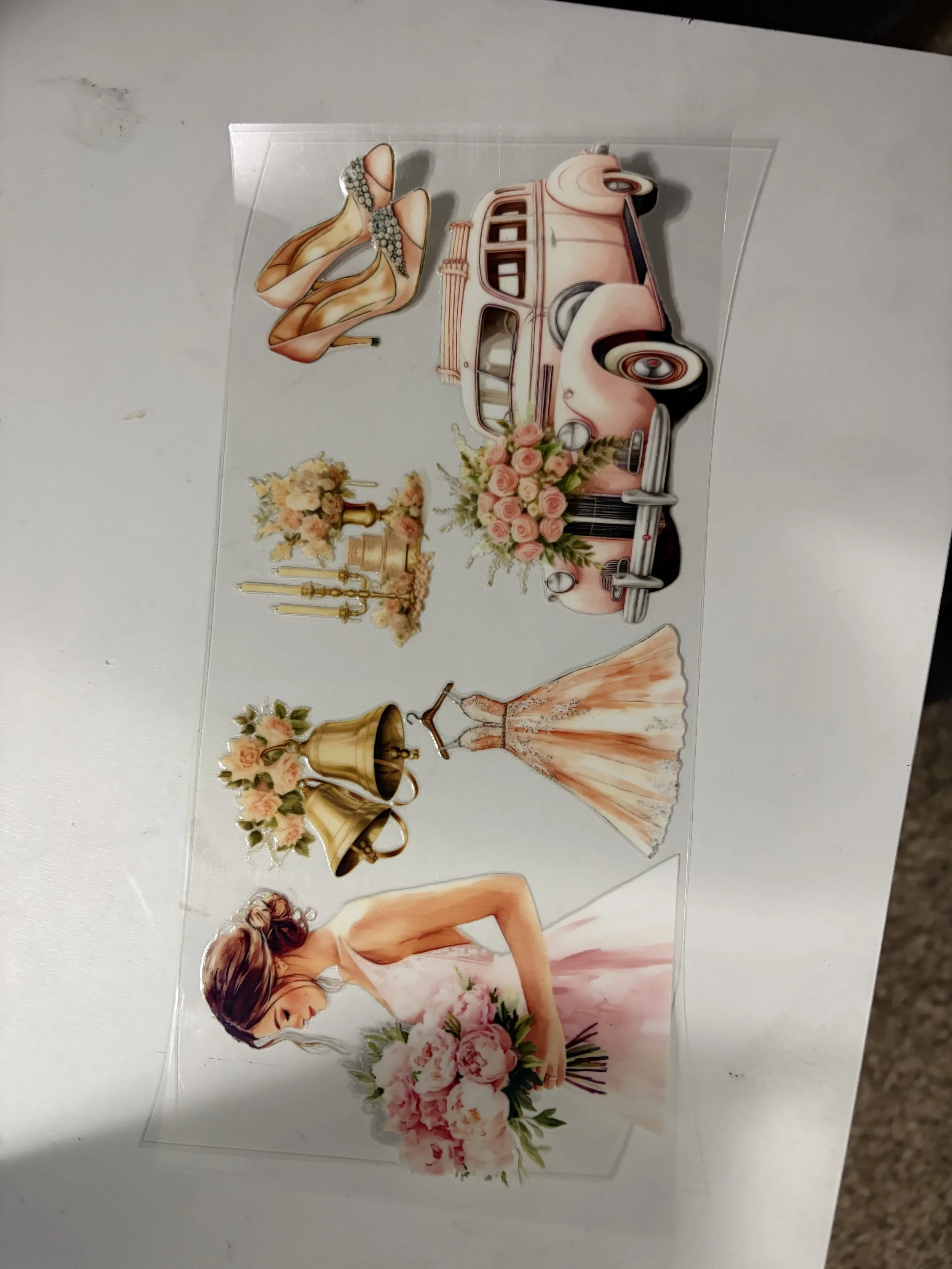 Decorative stickers featuring a vintage pink car with flowers, a pair of high heels, a bouquet of pink roses, chandeliers, and a woman in a strapless dress holding a bouquet of pink flowers.