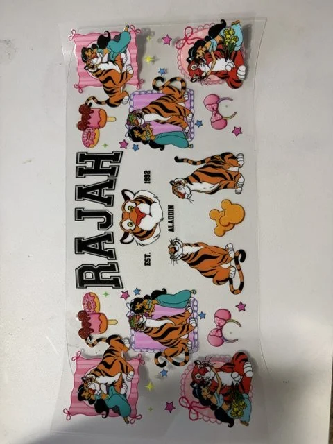 Colorful wall decal featuring Tigger decorating a room, with multiple Tigger illustrations in various poses and activities, and the text "RAJAH" in bold letters, along with other decorative elements.