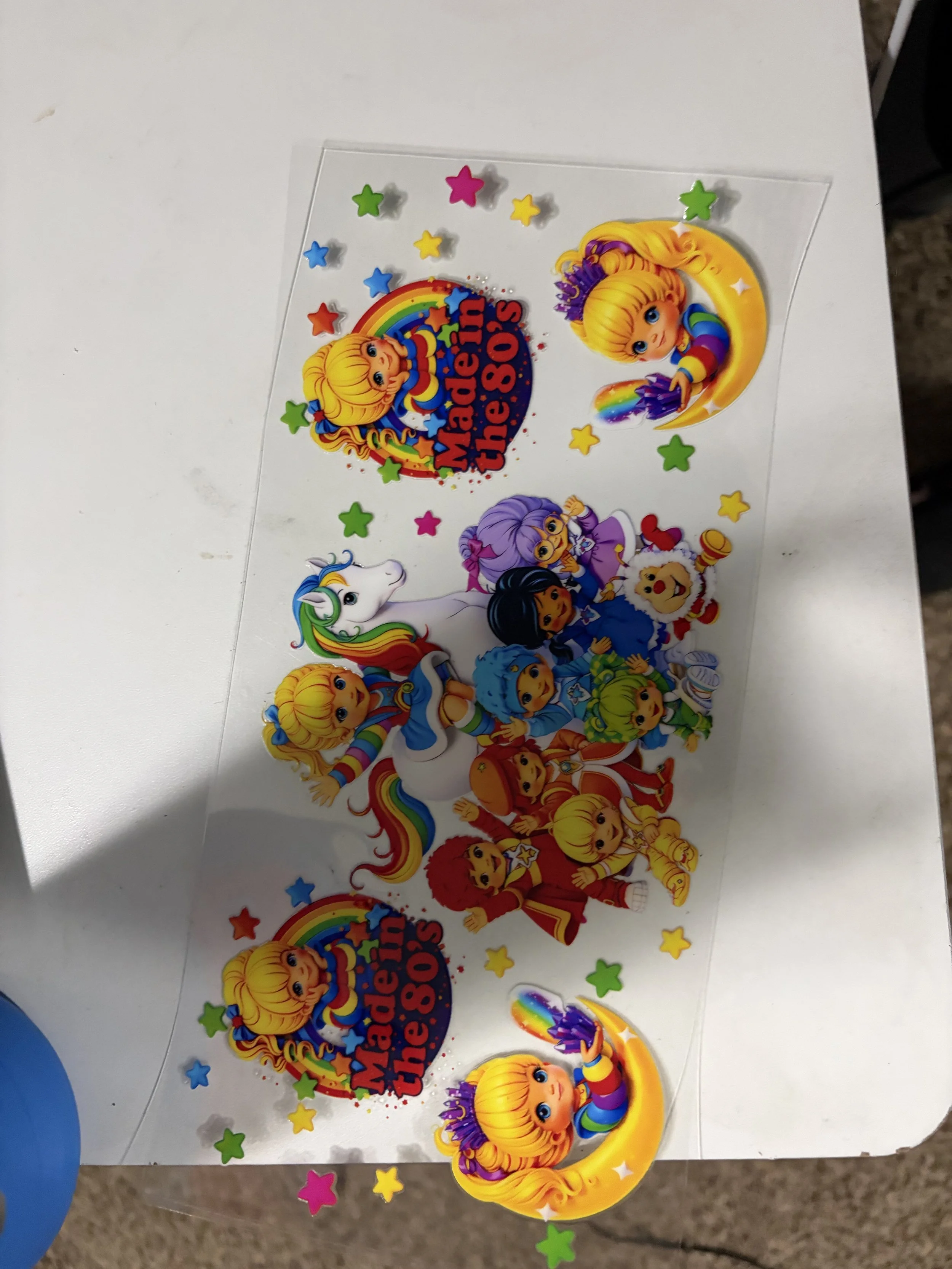 Colorful birthday sticker sheet with cartoon characters, rainbows, and stars, celebrating a 1980s theme.