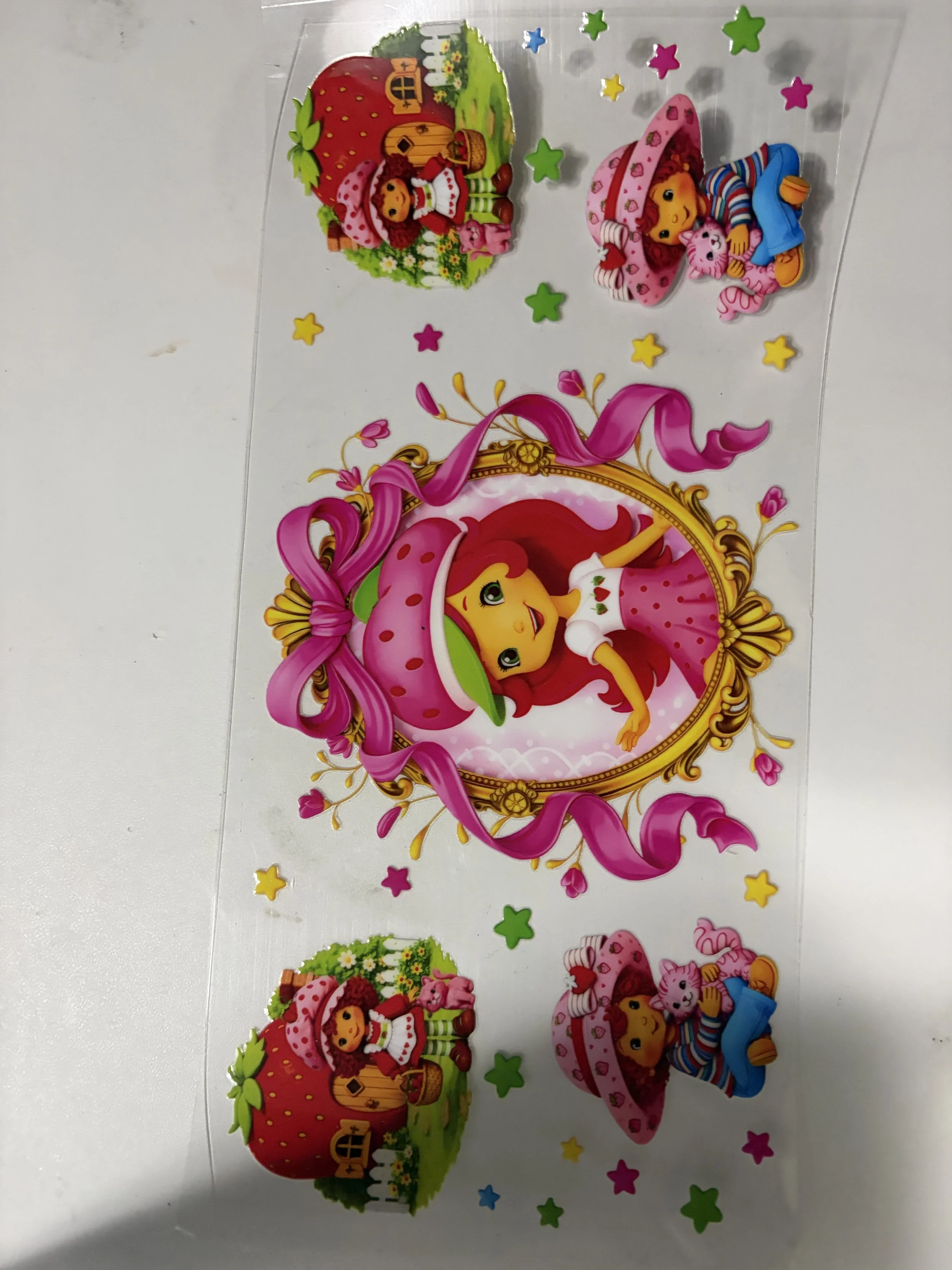 Colorful party decorations featuring a character of a girl with red hair, wearing a pink polka-dotted hat, and a striped shirt, lying on a pink and white blanket or bed, surrounded by stars and various decorative elements.