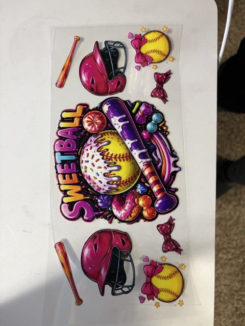 Colorful stickers with a softball theme, including softball bats, helmets, a large softball with the word 'SOFTBALL,' a baseball bat, and various candies, on a transparent sheet.