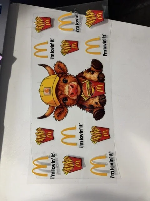 McDonald's promotional poster featuring a cartoon pig wearing a yellow construction helmet and holding a burger, surrounded by multiple McDonald's fries and logo images with the slogan 'I'm lovin' it'.