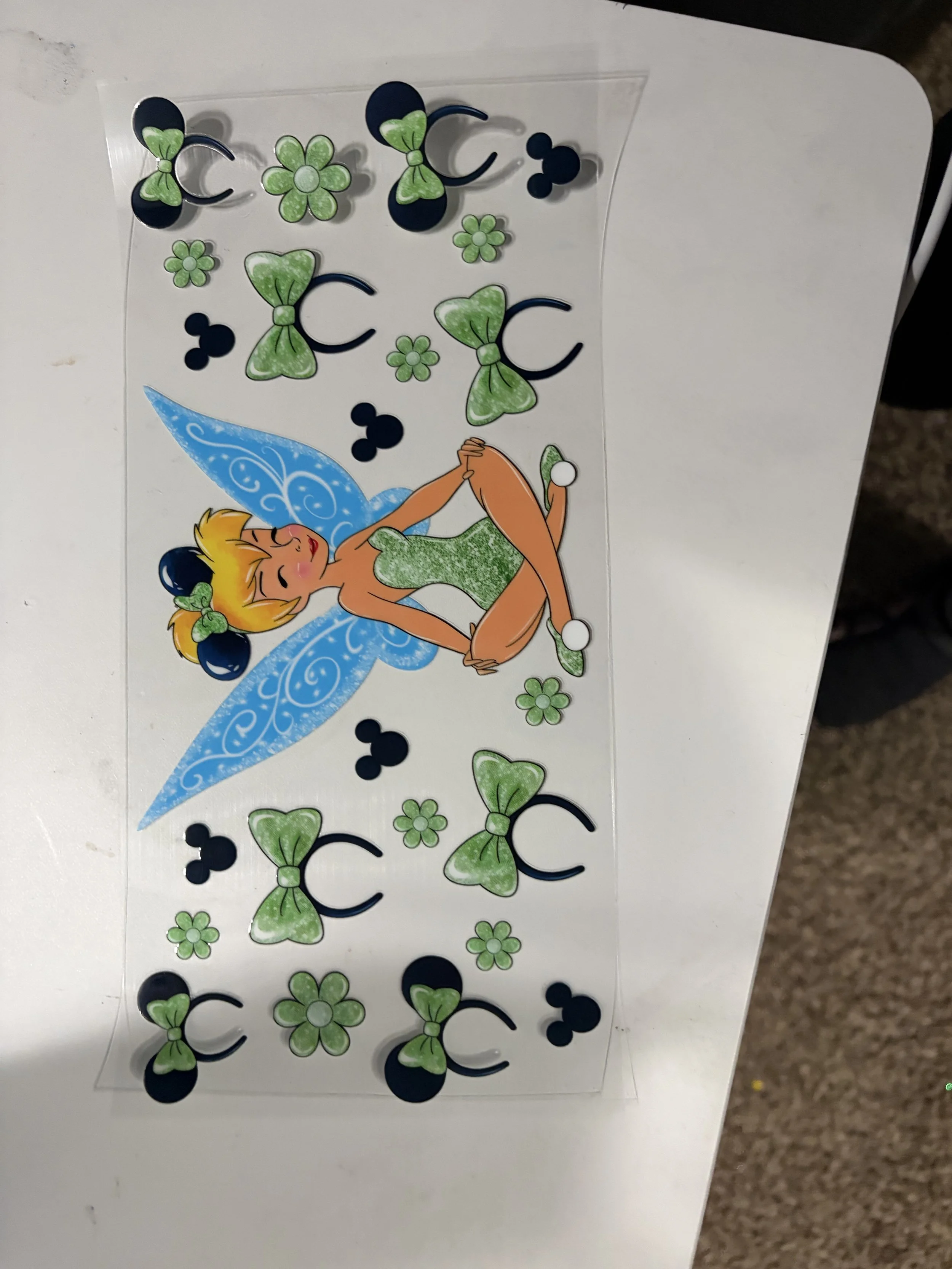 Colorful sticker sheet with fairy, flowers, bows, and butterflies on a white surface.