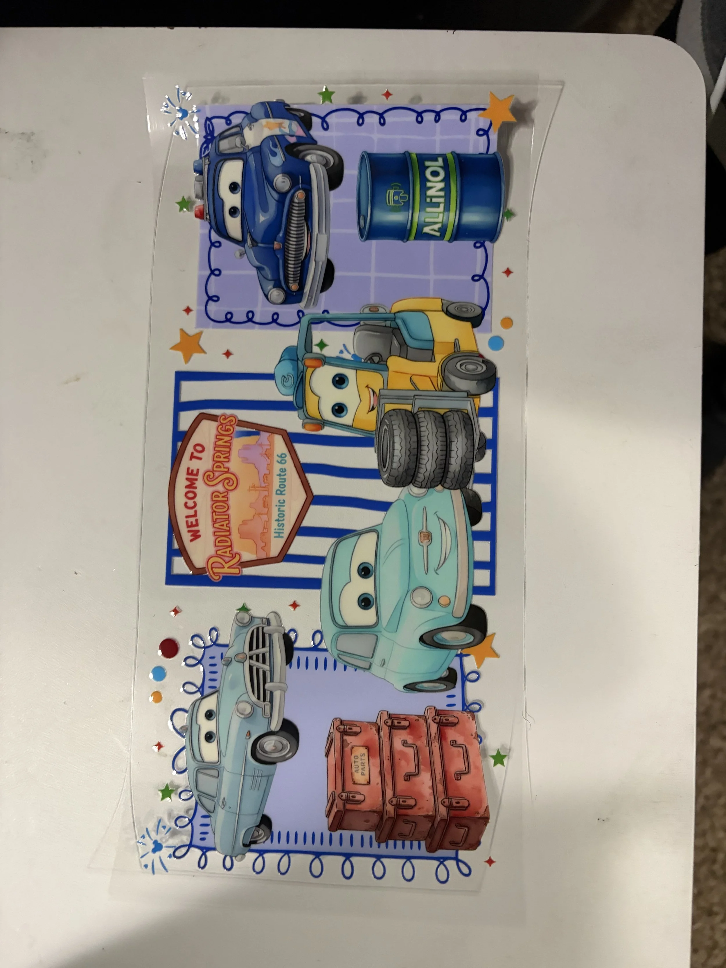 Colorful cartoon cars with smiling faces on a decorative background with stars, fireworks, and a welcome sign.