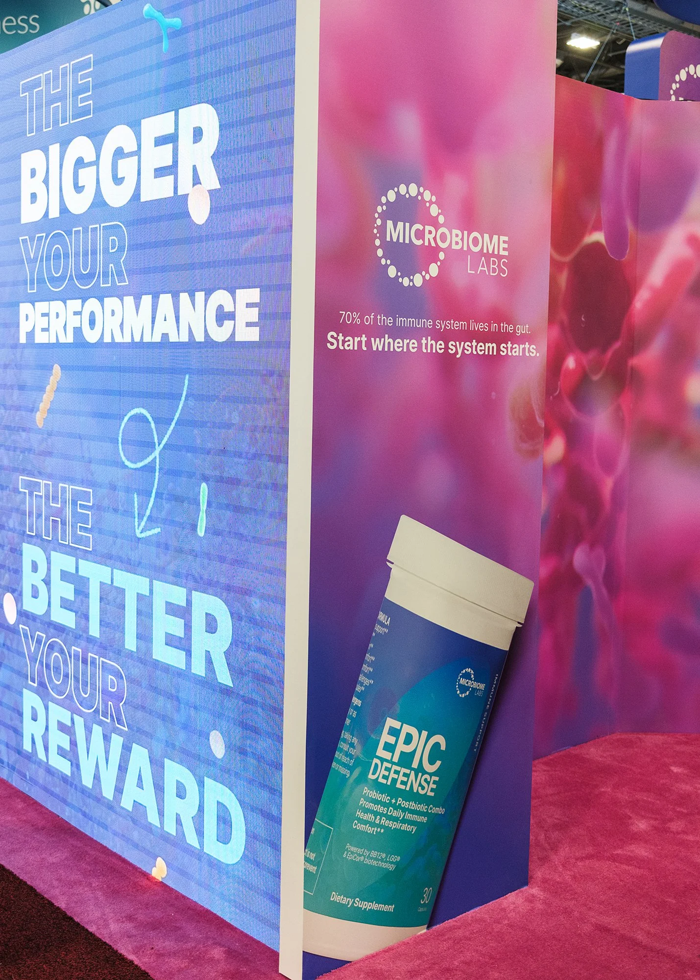 A display at a convention featuring Microbiome Labs products and promotional posters about gut health and performance enhancement.