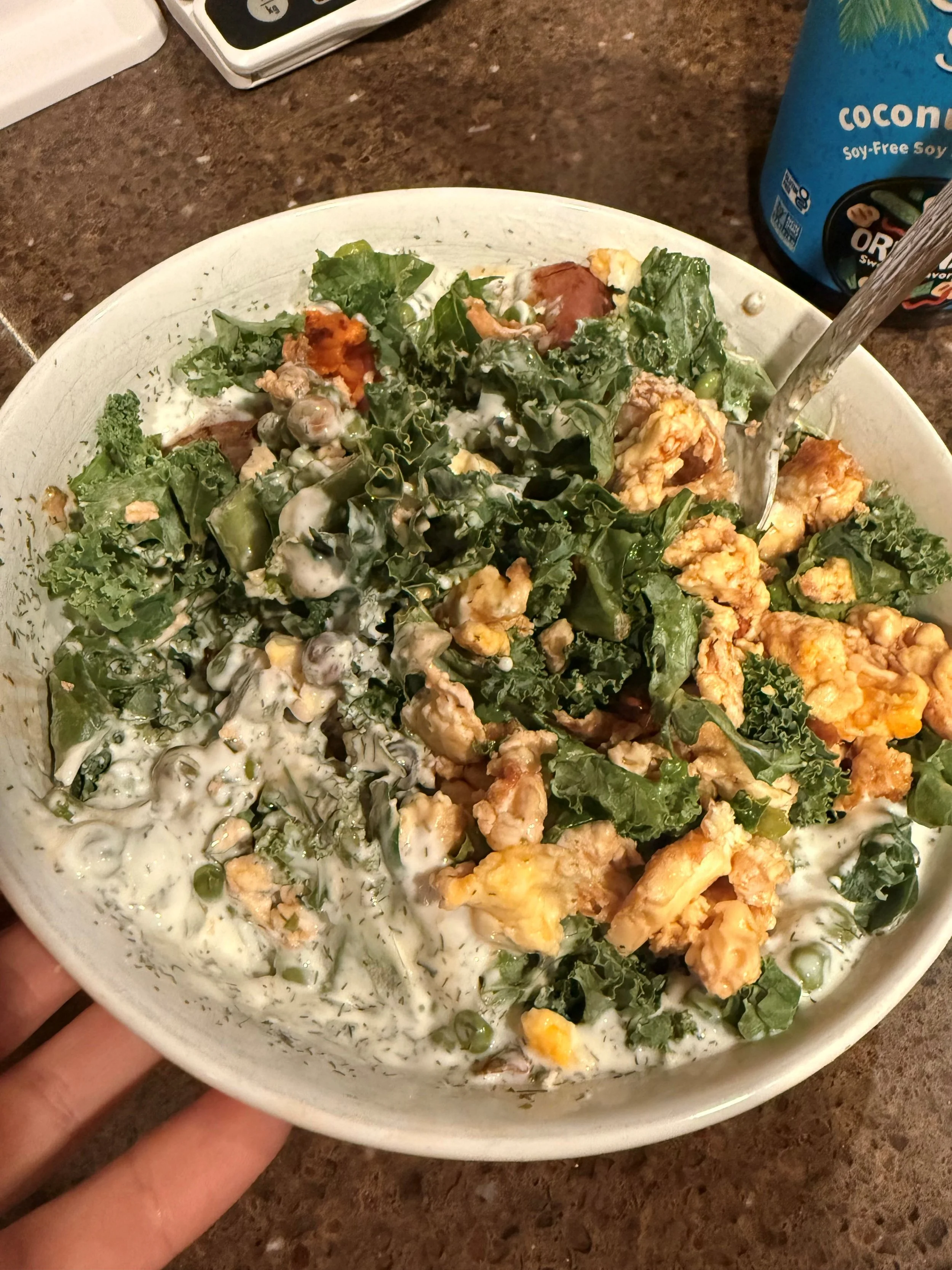 Plate of kale salad with creamy dressing, mushrooms, peas, and crispy fried toppings