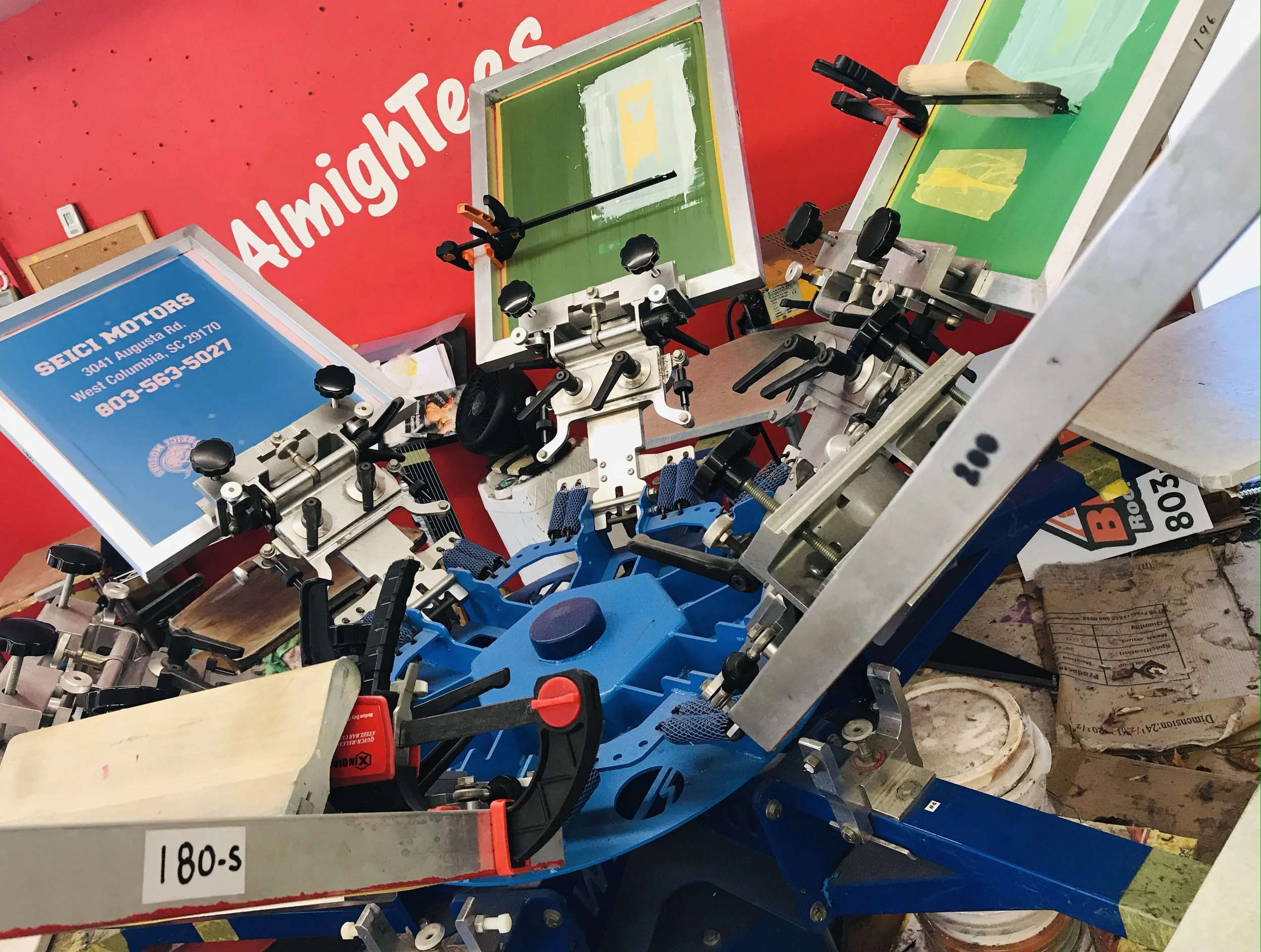 Manual screen printing press printing custom t-shirts in Lexington SC