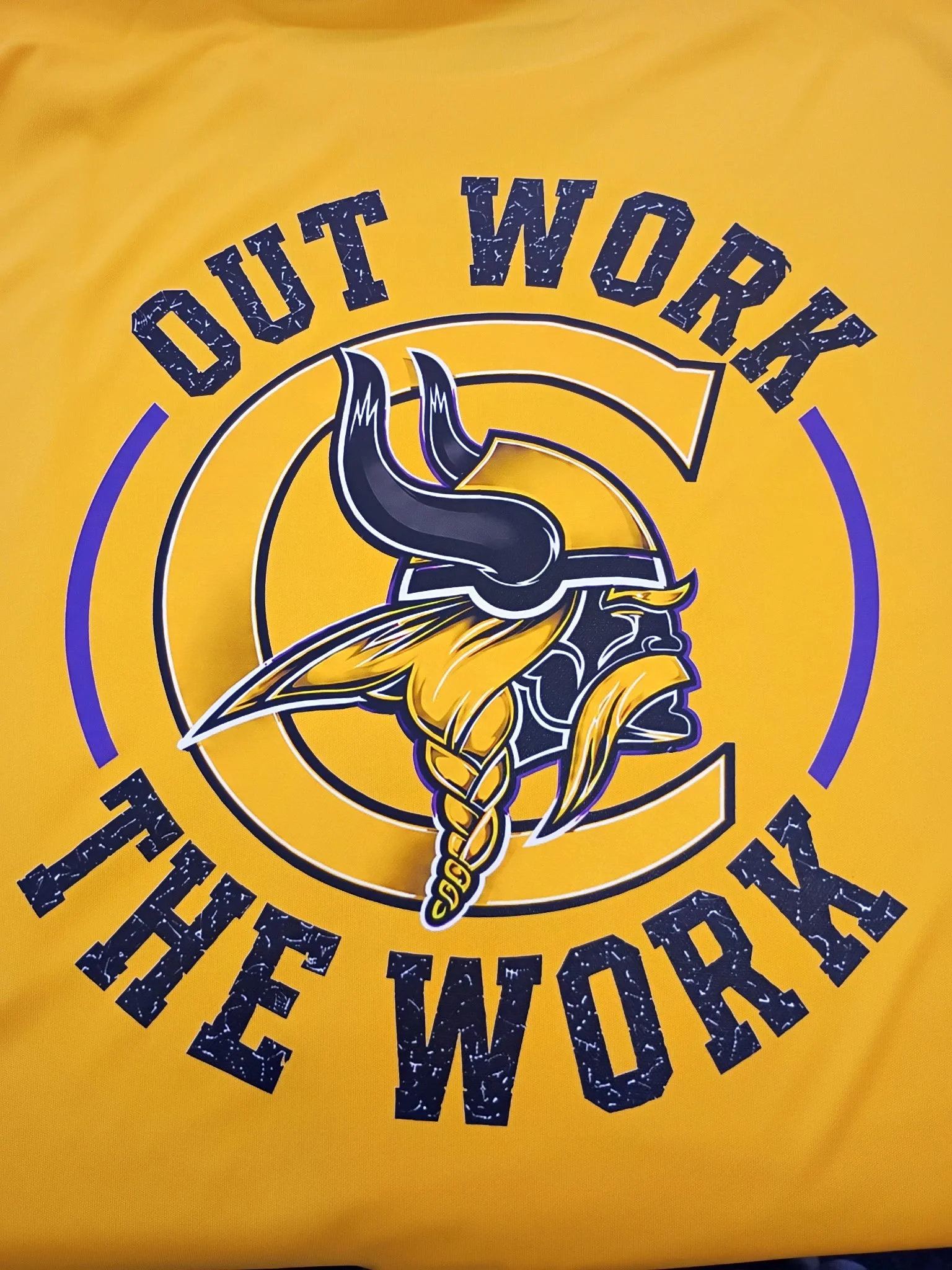 Yellow sports jersey with a Viking helmet DTF logo and the text 'OUT WORK THE WORK' around the logo.
