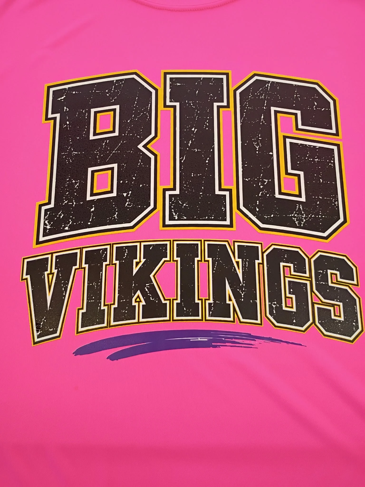 Close-up of a pink Columbia Vikings Direct To Film transfer logo with black, white, and yellow outline, and a dark purple brush stroke underneath.