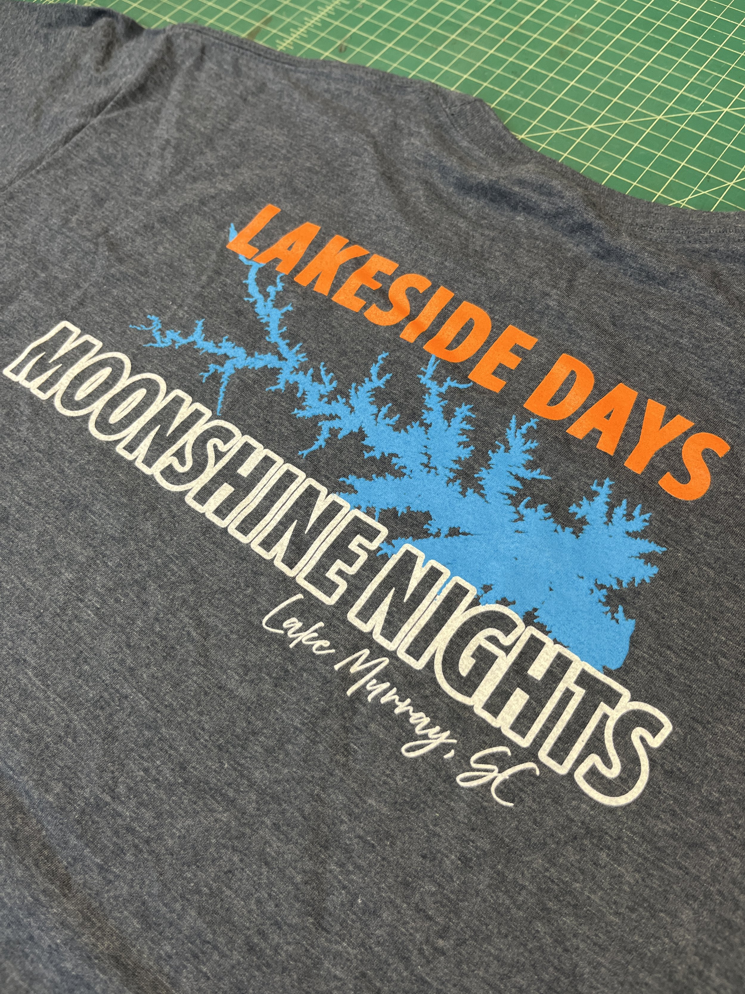 Heather Navy T-shirt with Lake Murray SC Lakeside Days logo and a blue lake graphic, Hollow Creek Distillery t-shirts.