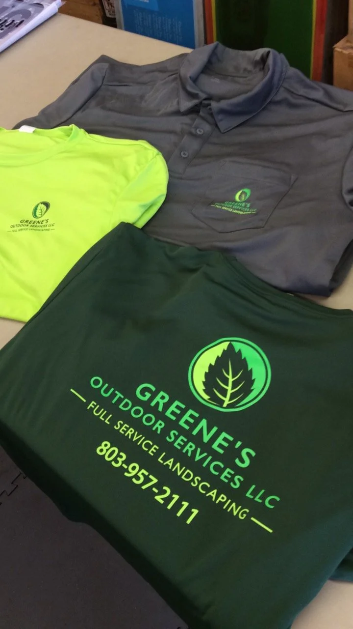 Three clothing items from Greene's Outdoor Services LLC: a gray polo shirt, a neon yellow T-shirt, and a dark green T-shirt, with company logos displayed. Landscaping t-shirts custom tees
