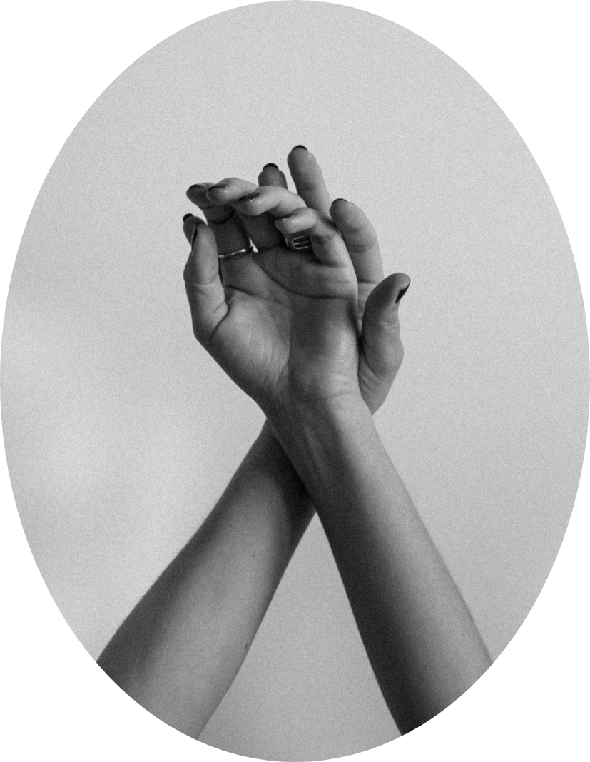 Two black and white hands interlocked and holding each other against a light background.