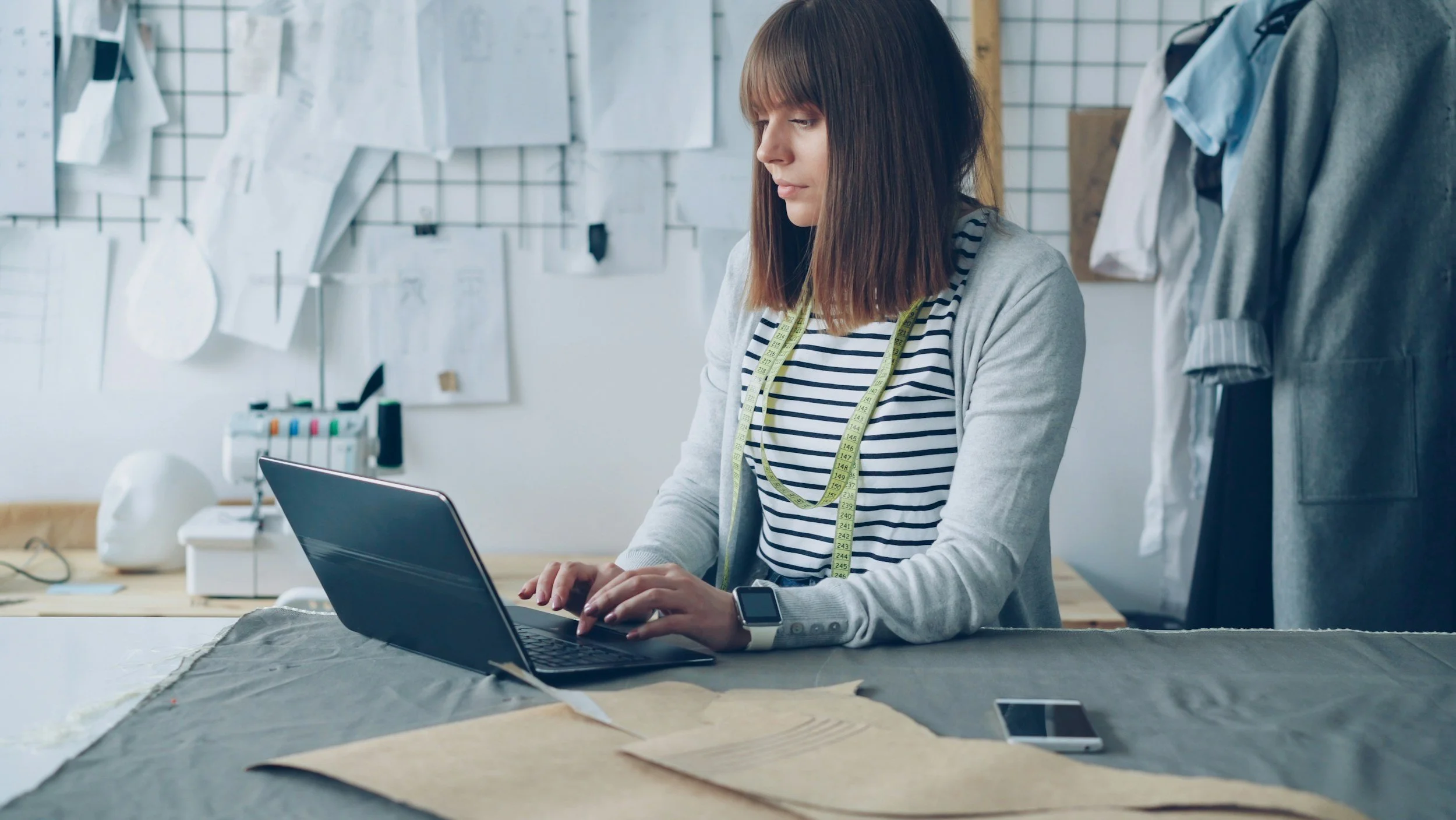 Small business owner working on a laptop, building custom operational systems for her business