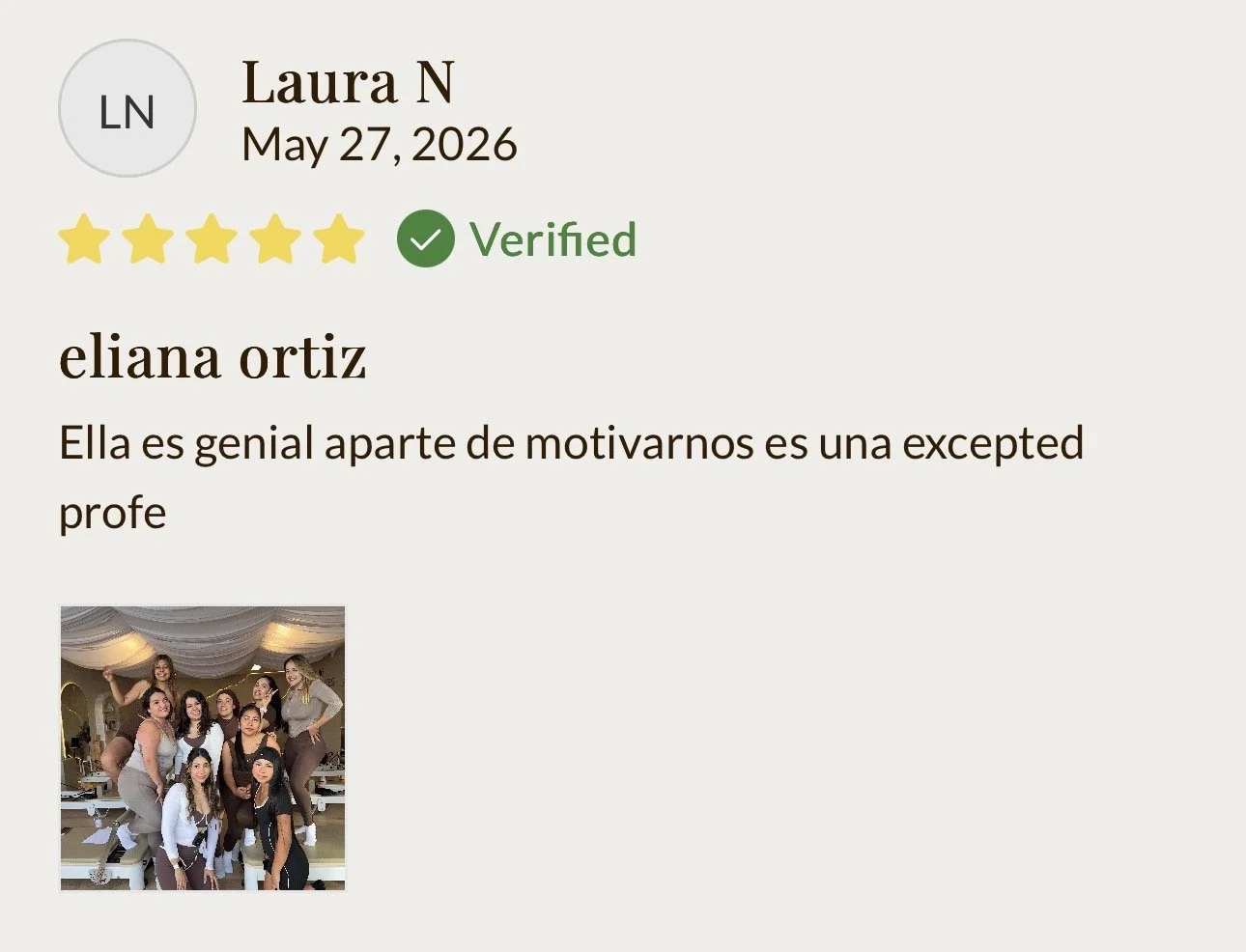 Grupo de mujeres posando juntos en un escenario o lugar decorado con cortinas blancas, algunas mujeres están de pie y otras están sentadas.