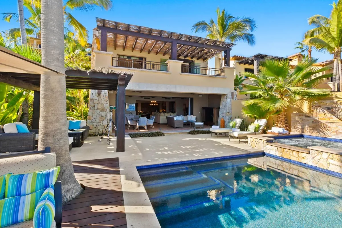Luxury house with outdoor pool and palm trees in a tropical setting.