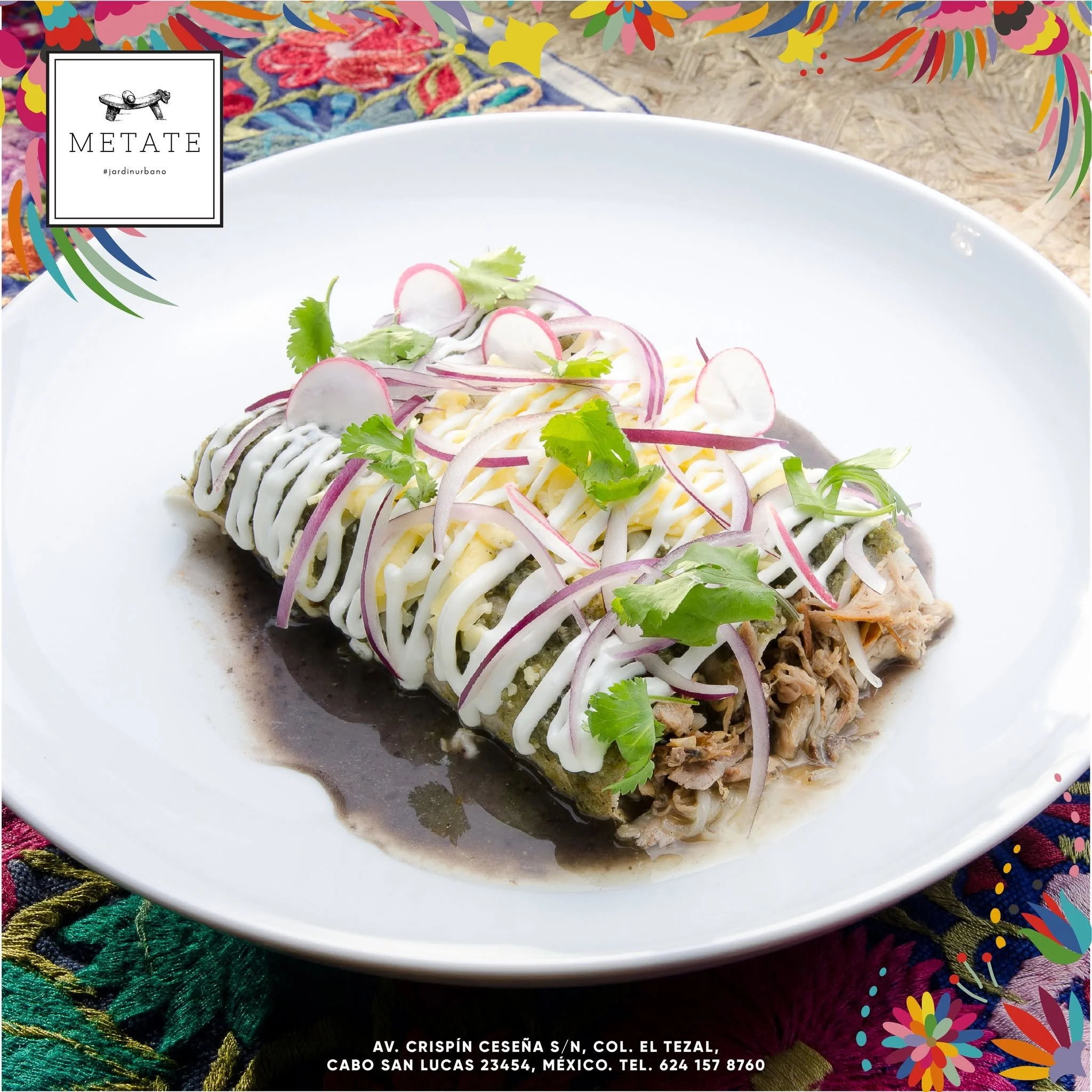 A plate with three tacos topped with sliced radishes, onions, cilantro, and drizzled with white sauce, set on a colorful, embroidered textile. Contact information for a location in Mexico is visible at the bottom.