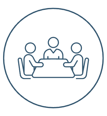 Three people sitting around a table in a meeting or discussion.